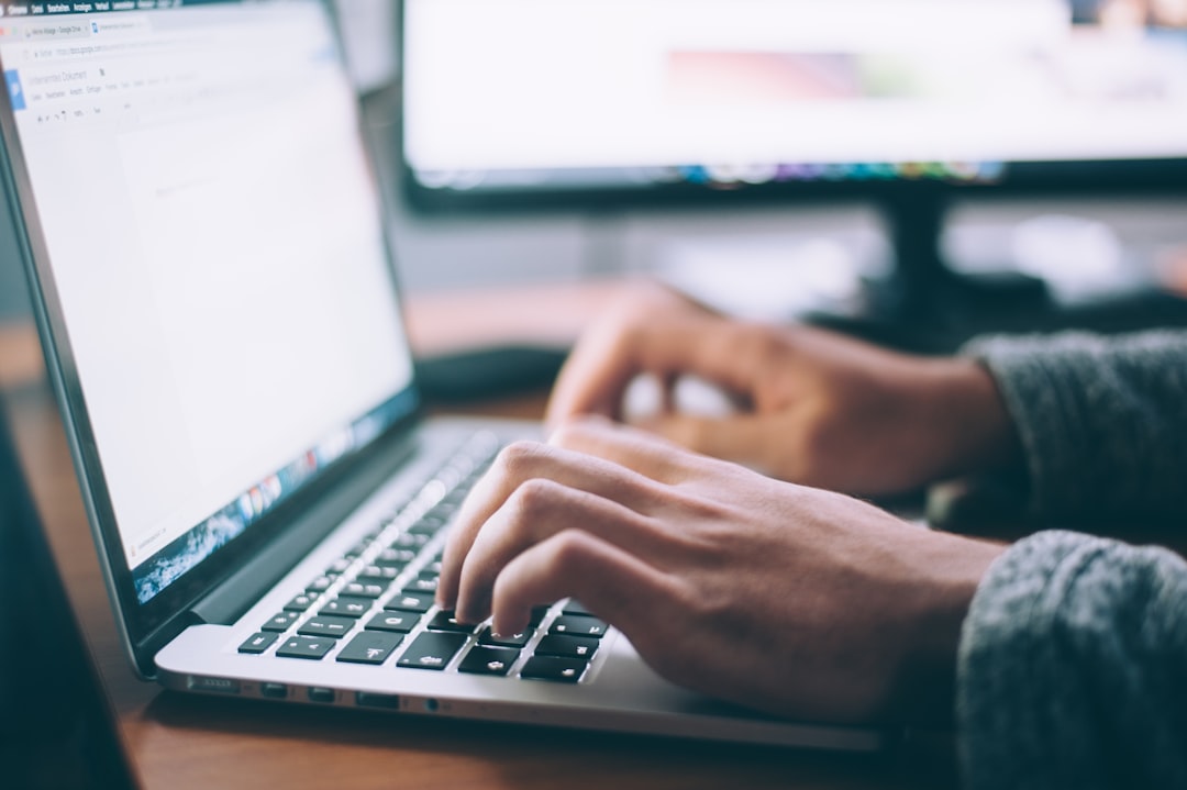 Person writing content on a laptop